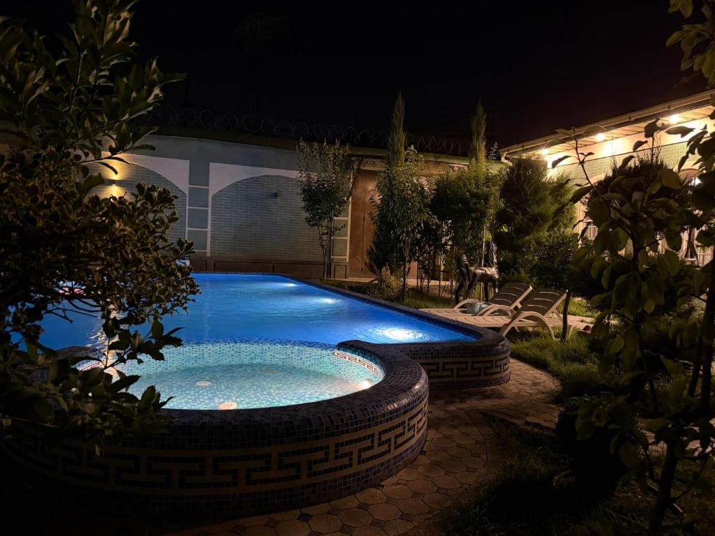 a swimming pool in a yard at night at Dacha by Bex Sueno in Samarkand