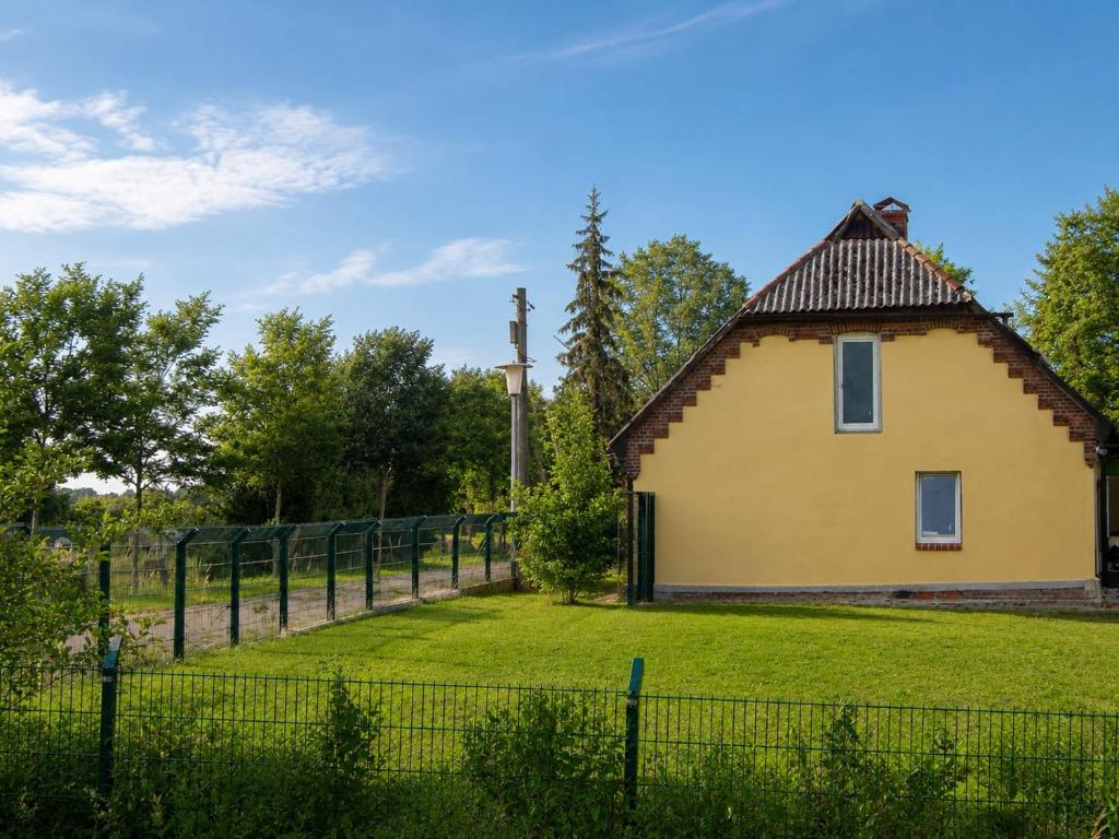a house in a field with a fence at Landhaus Klein Markow in Jördenstorf