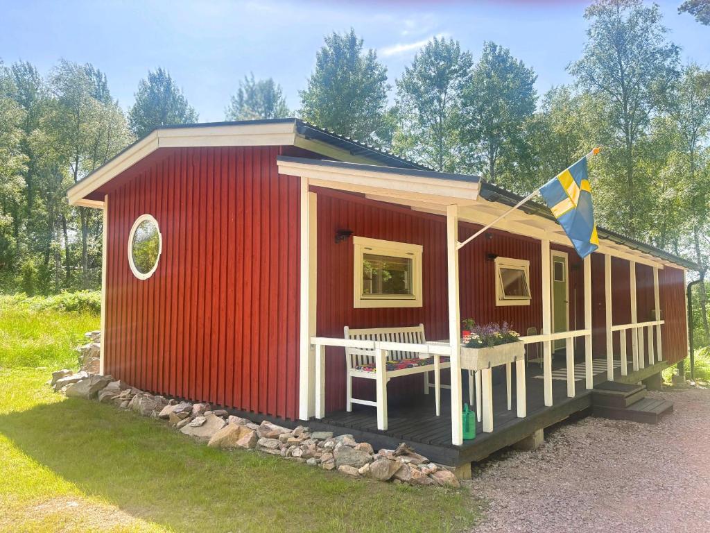 a red house with a flag on the front at Stuga Haget in Bengtsfors