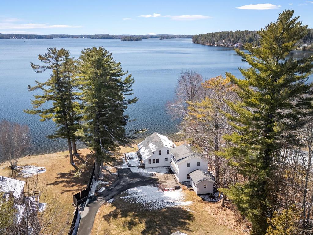 an aerial view of a house on the shore of a lake at Cobbossee Hideaway, lakefront property with dock for swimming, fishing, and sunrises in Winthrop