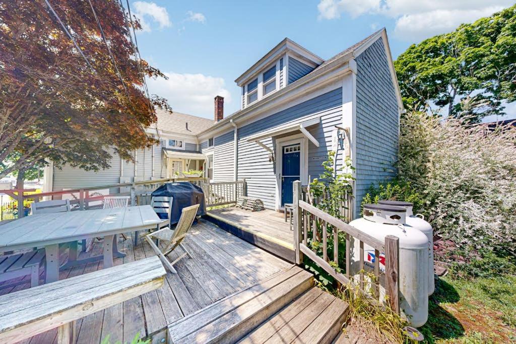 a house with a deck with a grill on it at Historic Boothbay Harbor cottage with antique decor, washer/dryer & deck in Boothbay Harbor