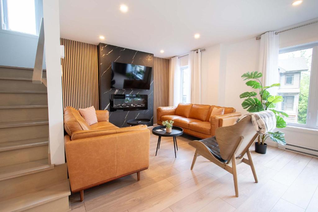a living room with leather furniture and a tv at Chalet Essentiel 76 in Saint-Faustin