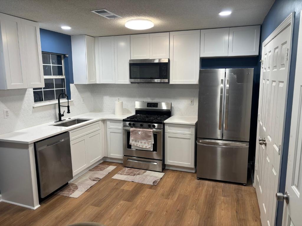 a kitchen with white cabinets and stainless steel appliances at Elegant luxurious paradise in Decatur