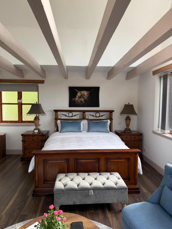 a bedroom with a bed and two tables and a couch at Ben Wyvis View Annexe in Inverness