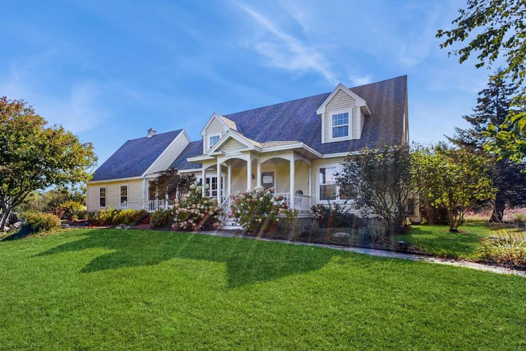 a white house with a large yard at Newly Renovated Charming House with Cozy Fireplace & Outdoor Entertainment Areas in Rockport