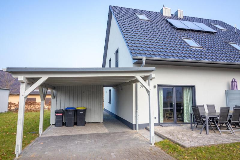 a white house with a patio with a table and chairs at Monique in Lenz