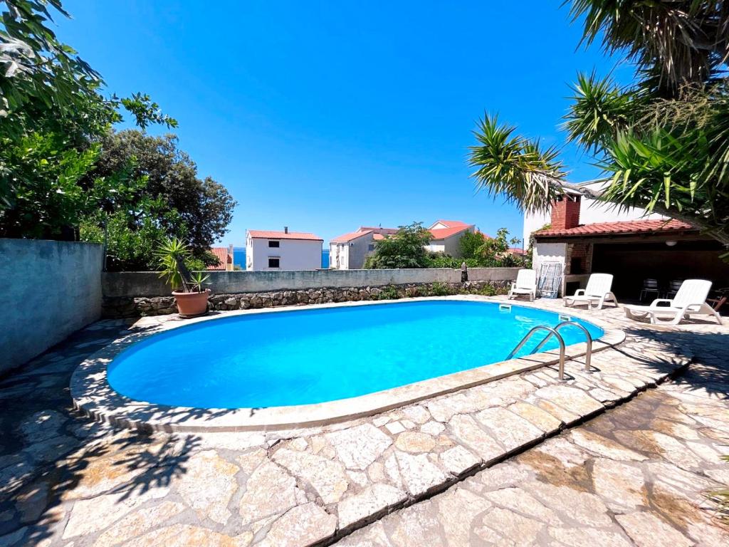 a swimming pool in a yard with two lounge chairs at Apartment Sofia in Kožino