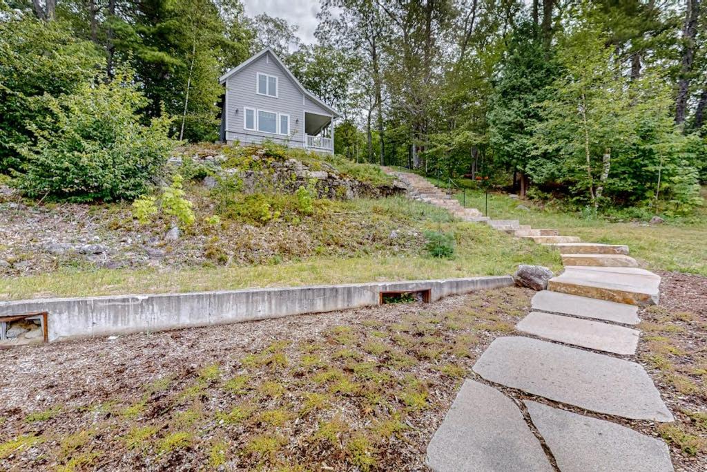 a stone path leading to a house on a hill at Periwinkle Cottage | Sunny cottage in Westport Island overlooking the river in Westport