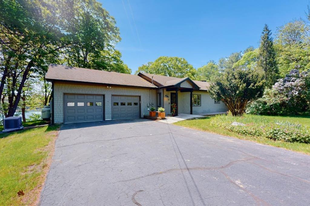 a house with a garage and a driveway at Water-view retreat with beach access, deck, grill, EV charger & lawn games in North Harpswell