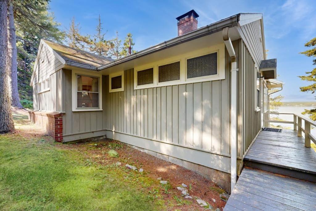 a small house with a porch and a deck at Beachfront Delight with detached guesthouse, private beach access, Dog-friendly in Southport