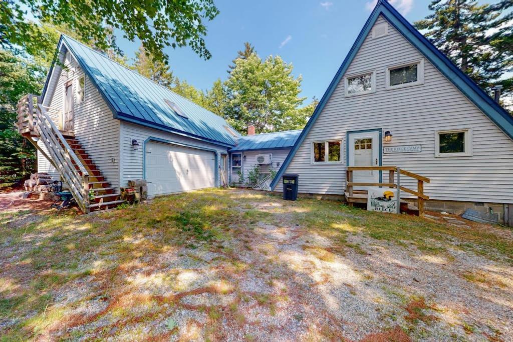 a large white house with a blue roof at Waterfront A-frame on George's Pond with views, private dock, beach, kayaks, SUP in Franklin