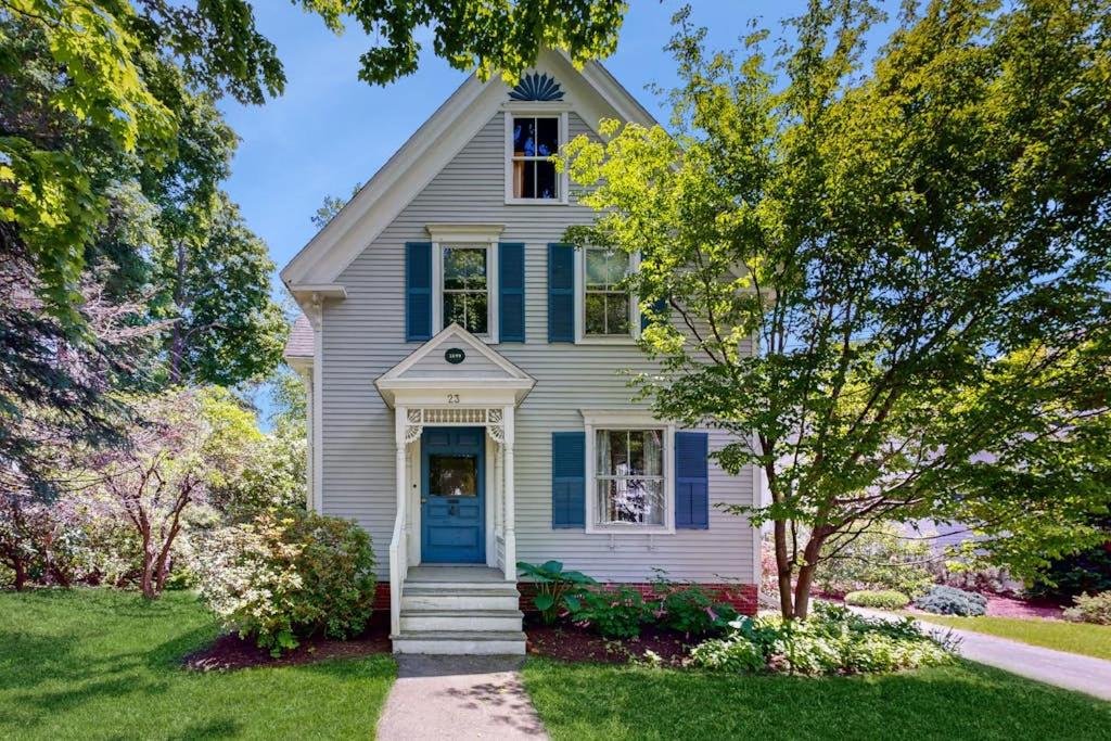 a white house with a blue door and trees at Parker House: Historic home - walk downtown, dog-friendly & washer/dryer in Camden