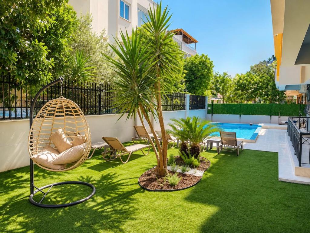 a backyard with a hammock and a palm tree at Berm Suites in Antalya