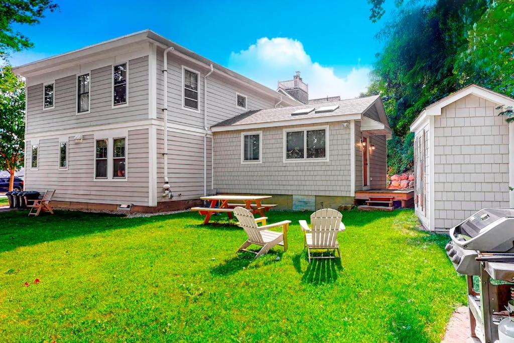 a house with a yard with two chairs and a table at Waterfront, walkable home with beautiful kitchen & washer/dryer - dog-friendly in Camden