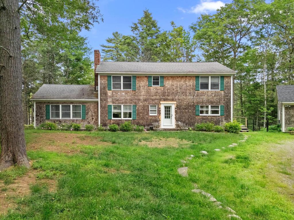 an old brick house with a yard at Tranquil private riverfront home w/ tidal dock & large yard in Boothbay