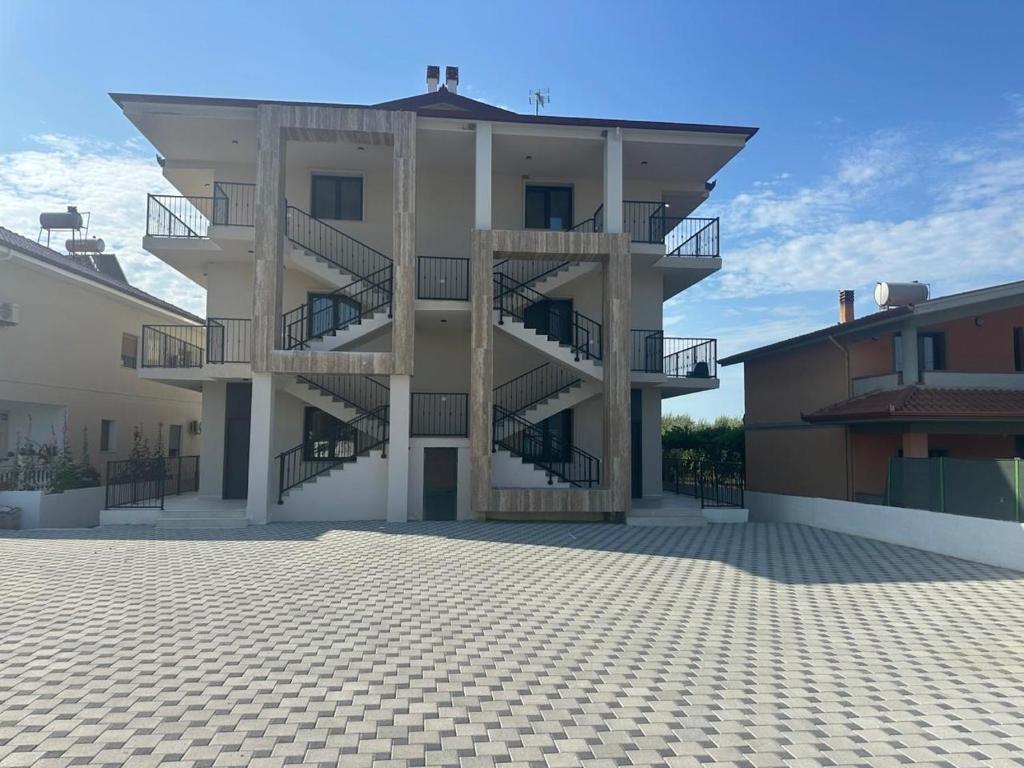 a building with stairs on the side of it at Apartament E&G in Rrogozhinë