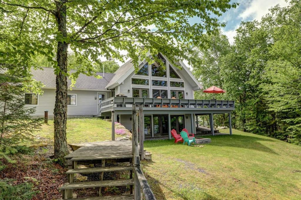 a large white house with a porch and a deck at Lakefront Chalet-Style Home with Large Deck, a Dock & Beautiful Lake Views in Greenville