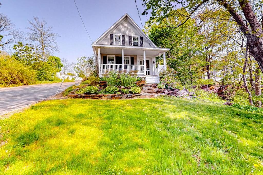 a white house on a hill with a yard at Classic home with prime location 1 block from Main Street in Bucksport