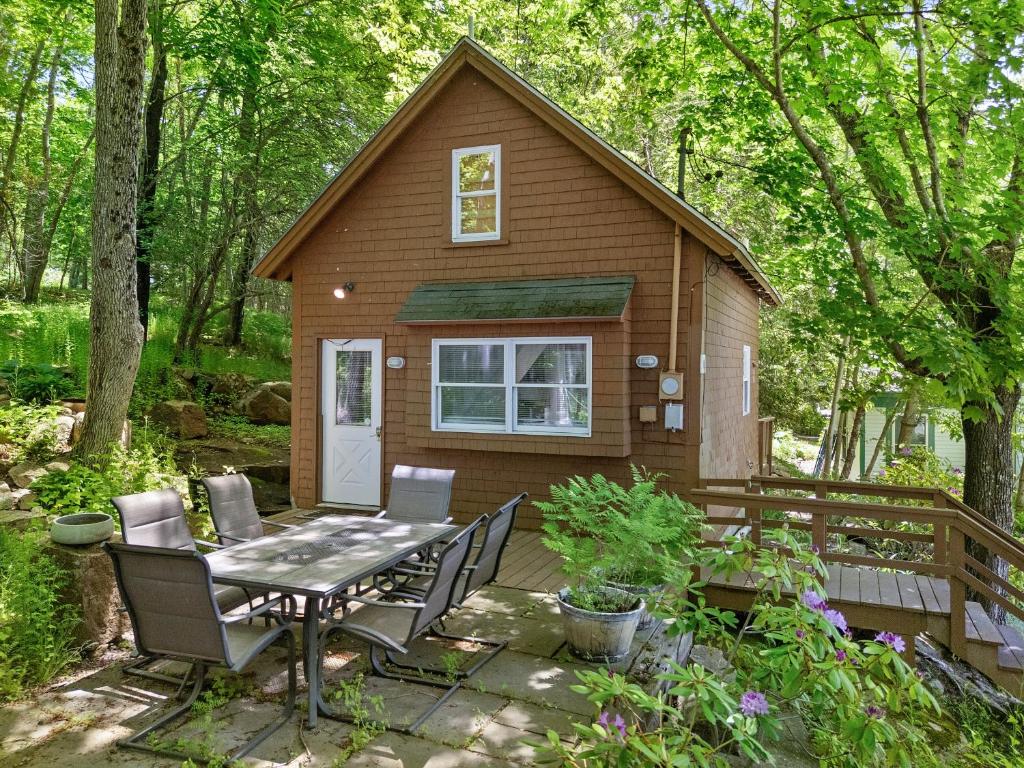 a tiny house in the woods with a table and chairs at Two-Level Unit w/ Patio, Deck, Firepit, Private Washer/ Dryer, and Free WiFi in Seal Harbor