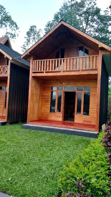a large wooden house with a deck on a yard at Home stay TB in Palayangan