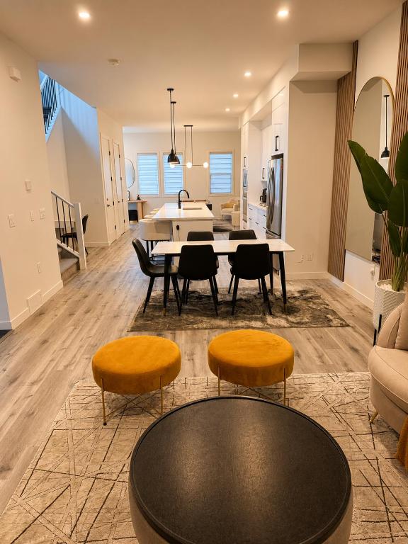 a dining room and living room with a table and chairs at Emerald - 10mins from Stampede Park in Calgary