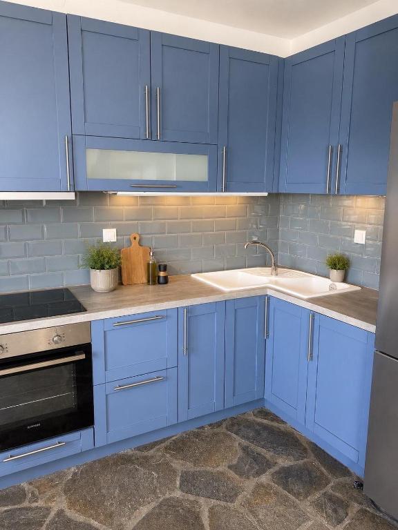 a kitchen with blue cabinets and a sink at Ioannis Appartements Glossa in Glossa