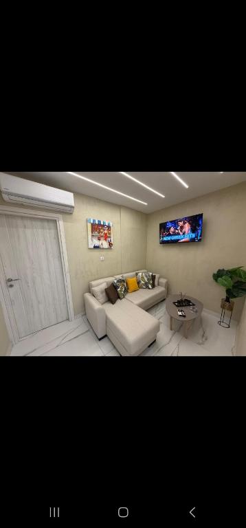 a living room with a couch and a tv at Aggelos Room 4 in Volos