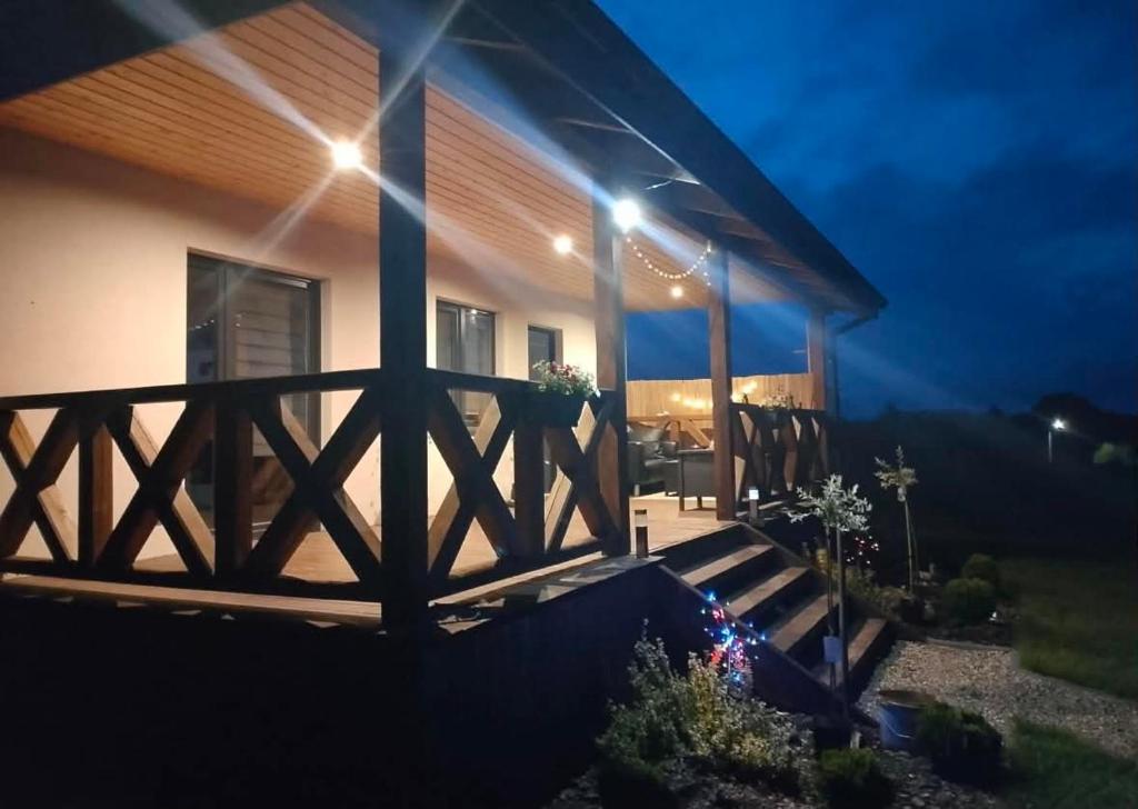 a house with a porch at night with lights at Wakacyjne relaksacyjnie in Szczytno