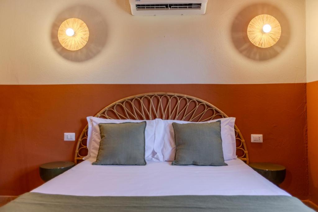 a bed in a room with two pillows on it at L'Agrumeto domos in Teulada