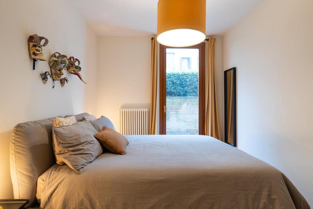 a bedroom with a bed with a large window at Ca' Dei Bolzeri in Venice