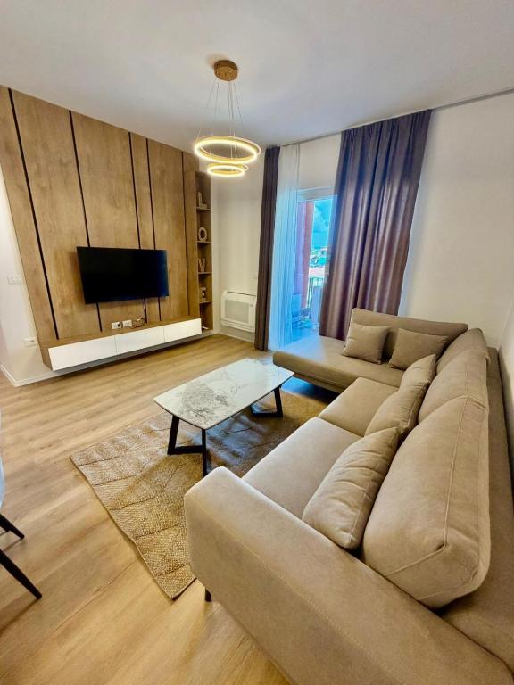 a living room with a couch and a flat screen tv at Golden Space Apartment 3 in Tirana