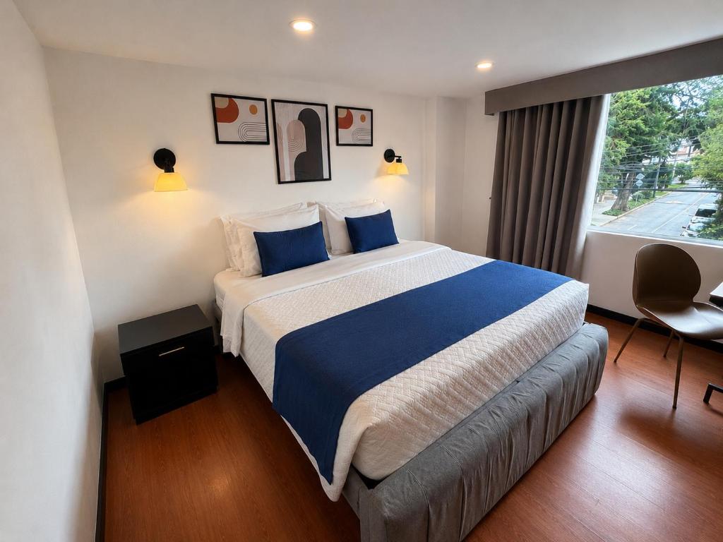 a hotel room with a large bed and a window at Hotel Embajada 44 in Bogotá