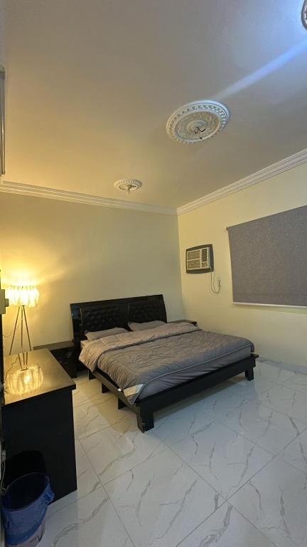 a bedroom with a bed and a table and a ceiling at رابغ in Rabigh