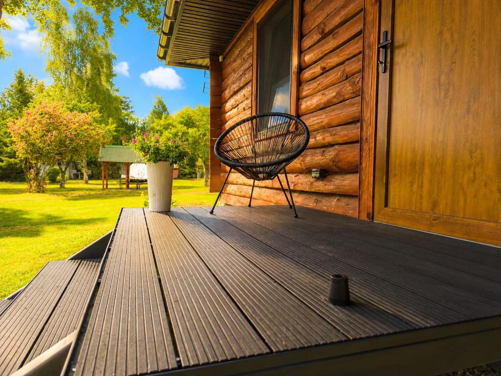 a bench sitting on the porch of a house at Wśród Drzew - Tykocin in Tykocin