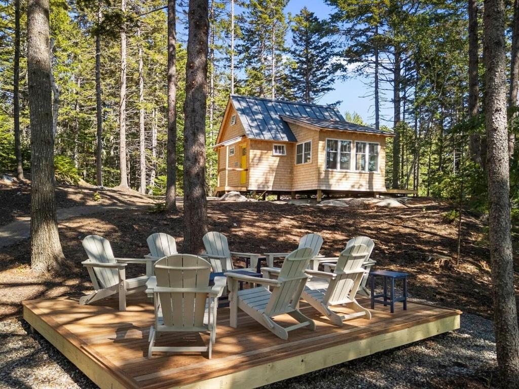a group of chairs and a table in front of a cabin at Lindquist Cottage | Waterfront Studio with King Bed in Clark Island