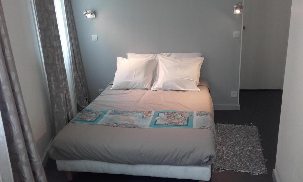 małe łóżko z dwoma poduszkami w obiekcie Le Kleber w mieście Montreuil
