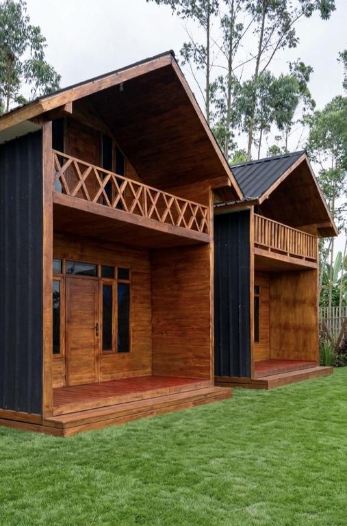 a small wooden house with a green lawn at Home Stay TB2 in Palayangan