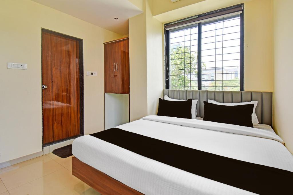a bedroom with a large bed and a window at Hotel O RVC GRAND CENTRAL in Viman Nagar