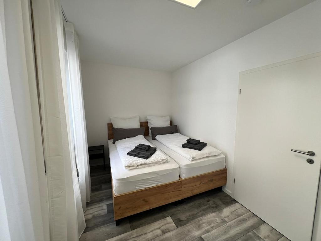 a small bedroom with a bed in a white room at Jagsttalglück in Neudenau