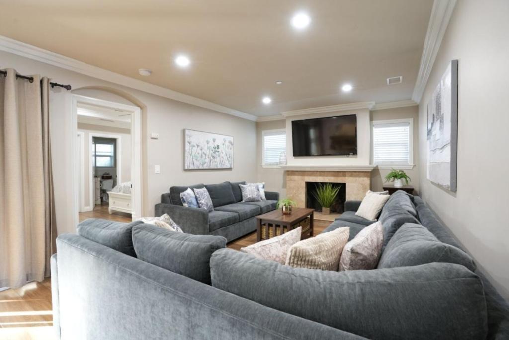 a living room with a large couch and a tv at Lavish 5 Bedroom, 4 Bath Pool Home 3/4 Mile To Disney in Anaheim