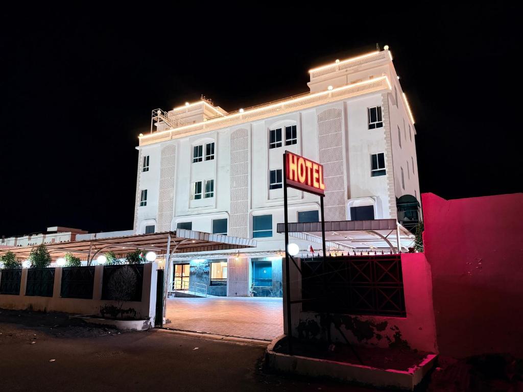 a white building with a motel sign in front of it at Al Barka Palace Hotel in Ma‘ābīlah