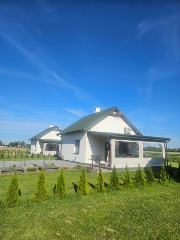 a large white building with a pitched roof at Letnisko nad jeziorem in Skulsk