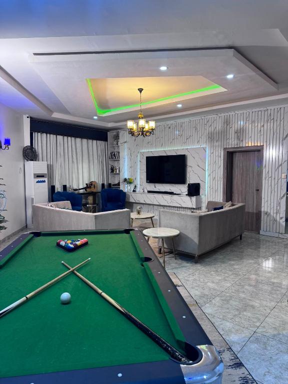 a living room with a pool table and a couch at Stone and Beam apartment in Abuja