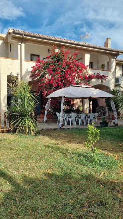 a house with a table and chairs under an umbrella at Casa Manchia in Loiri