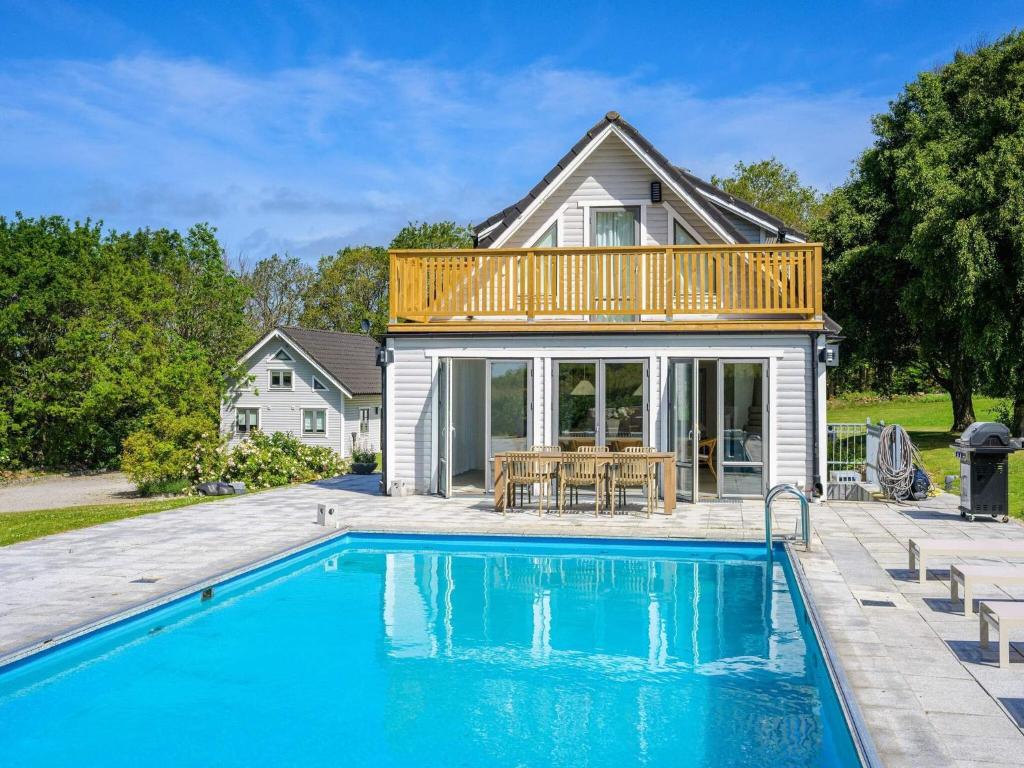 a house with a deck over a swimming pool at 12 person holiday home in BÅSTAD-By Traum in Båstad