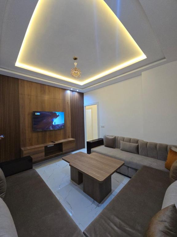 a living room with a couch and a table and a tv at Plage & Confort in Fnidek