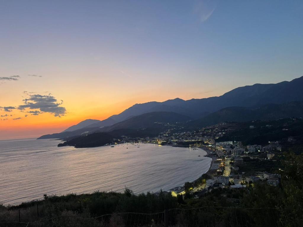 Blick auf eine Stadt und das Meer bei Sonnenuntergang in der Unterkunft Solemare in Himarë