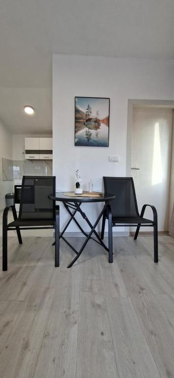 a room with a table and two chairs in it at JMM Apartment in Kotor