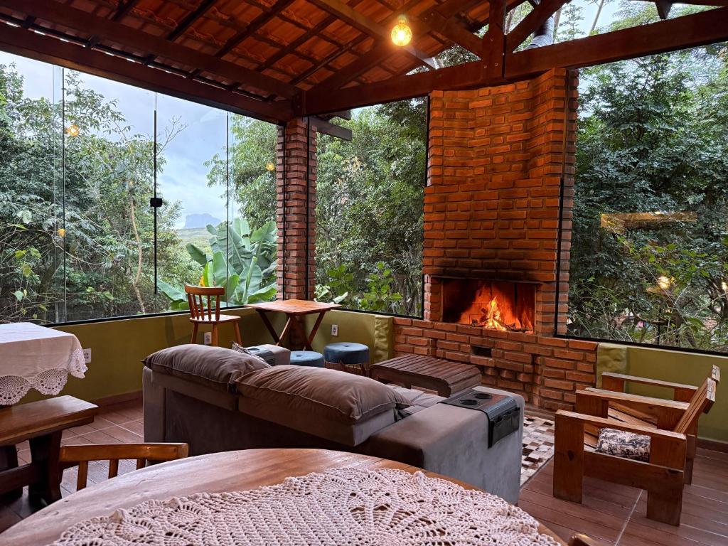 a living room with a couch and a fireplace at Vila Clara do Capão in Vale do Capao