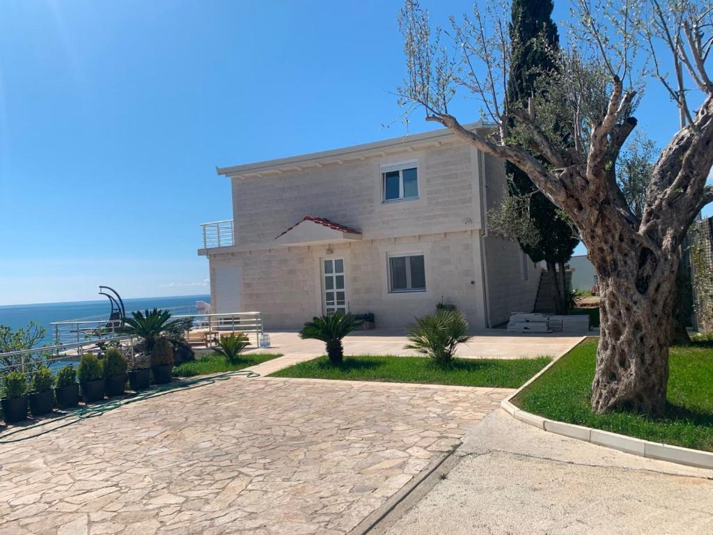 a large white house with a tree in front of it at Haus am Strand in Bar